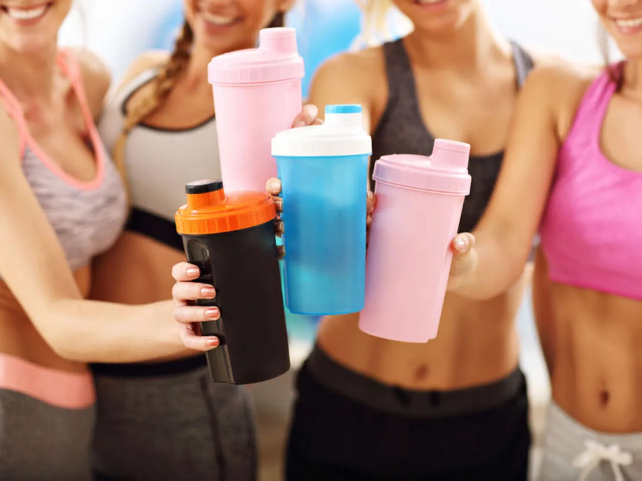 Kobieta pije koktajl białkowy po treningu