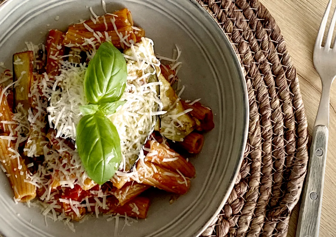 Pasta alla Norma piatto finito con ricotta salata e basilico