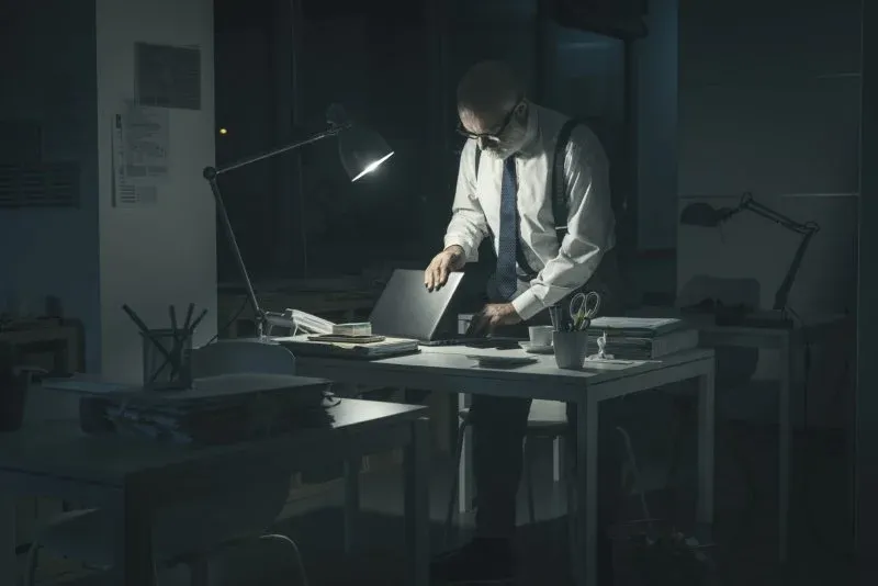 osoba pracująca na laptopie w domu po godzinach