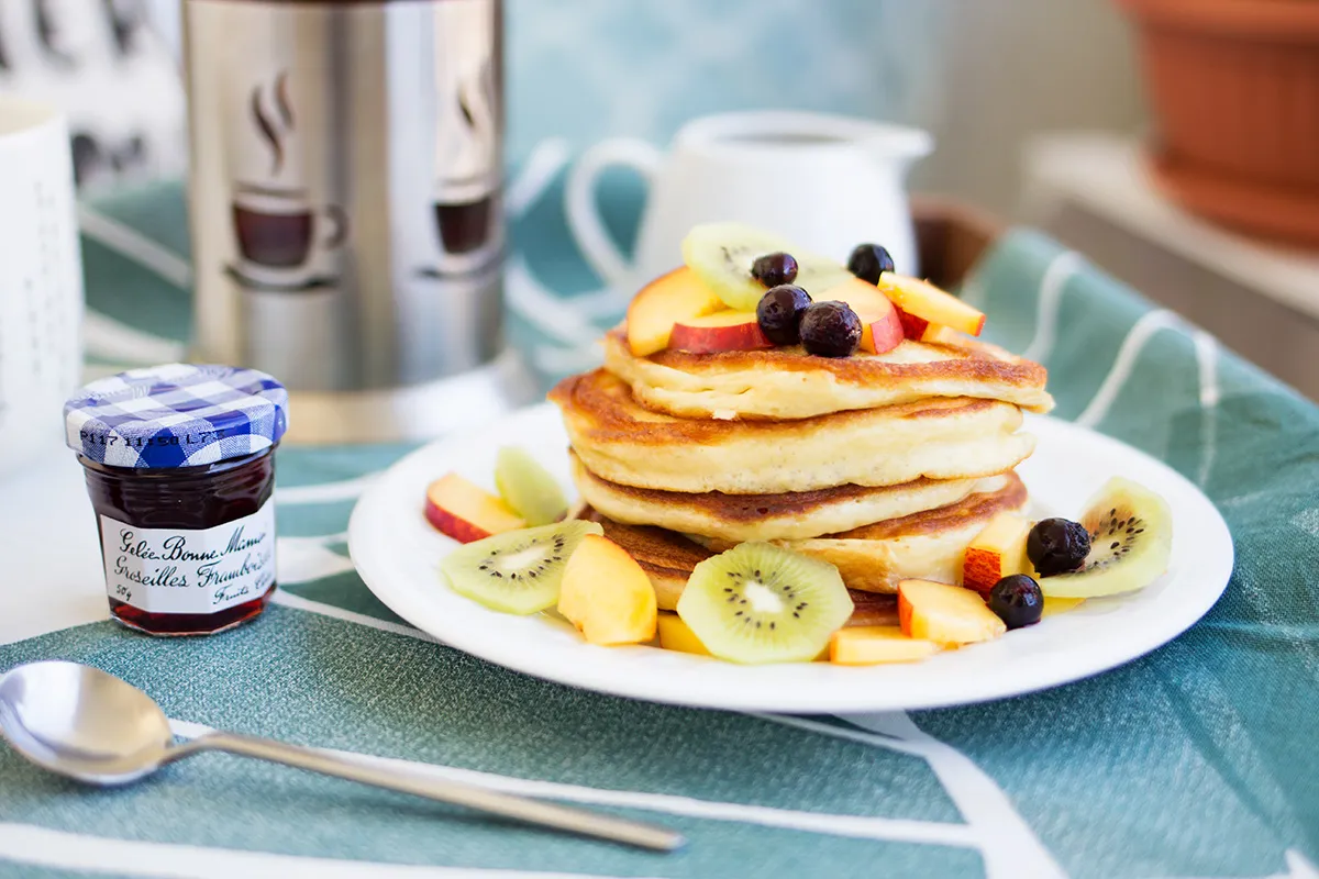 Pyszne naleśniki z owocami kiwi, brzoskwinią i borówkami. Idealne zdrowe przepisy na śniadanie, podane z dżemem.