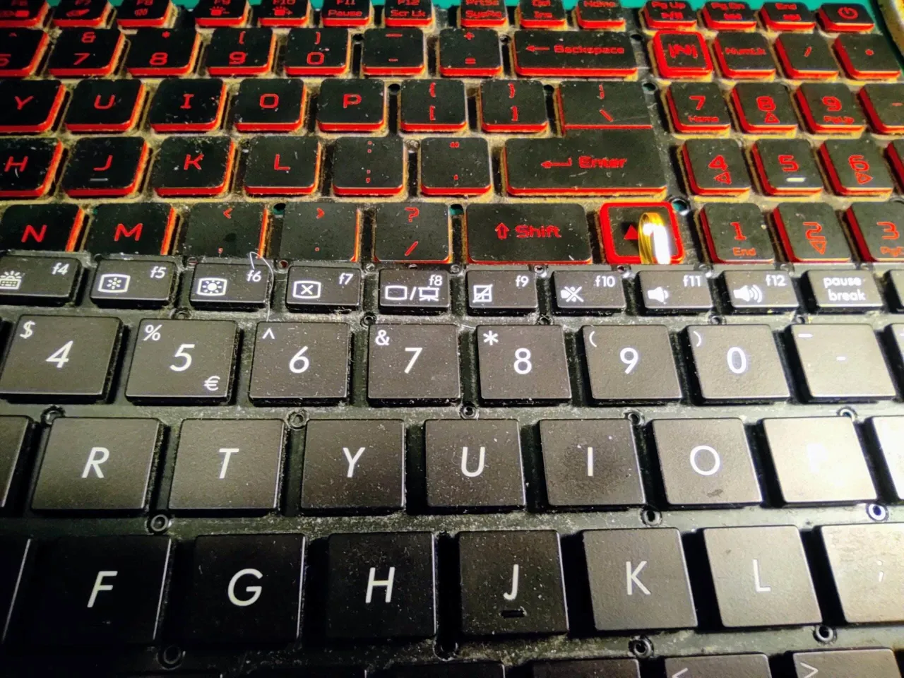 Klawiatura laptopa z czerwonym podświetleniem. Zastanawiasz się, ile kosztuje wymiana klawiatury w laptopie?