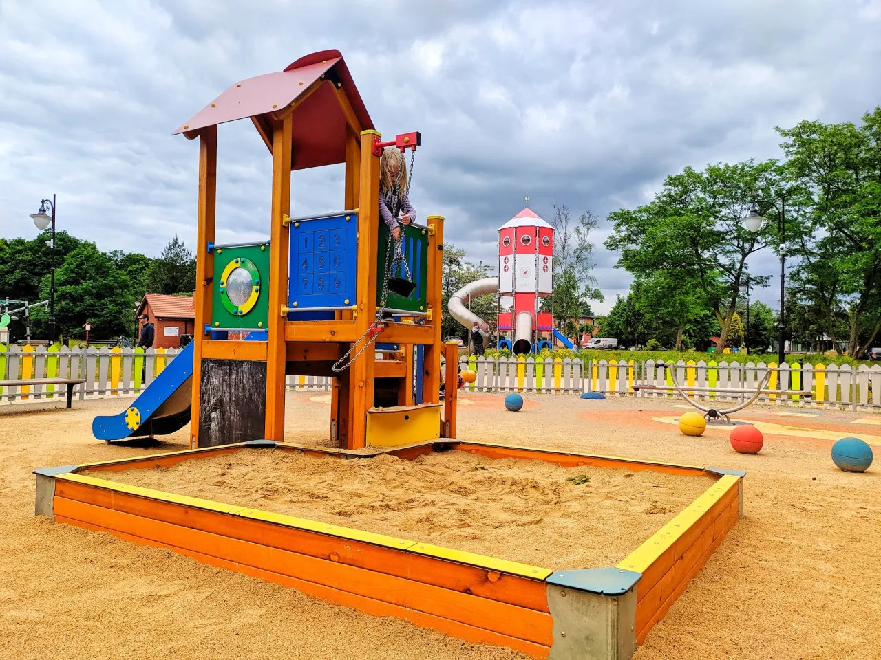 Kolorowy plac zabaw z piaskownicą, zjeżdżalnią i huśtawką. To świetne atrakcje dla dzieci w Brzegu, gdzie można spędzić aktywnie czas.