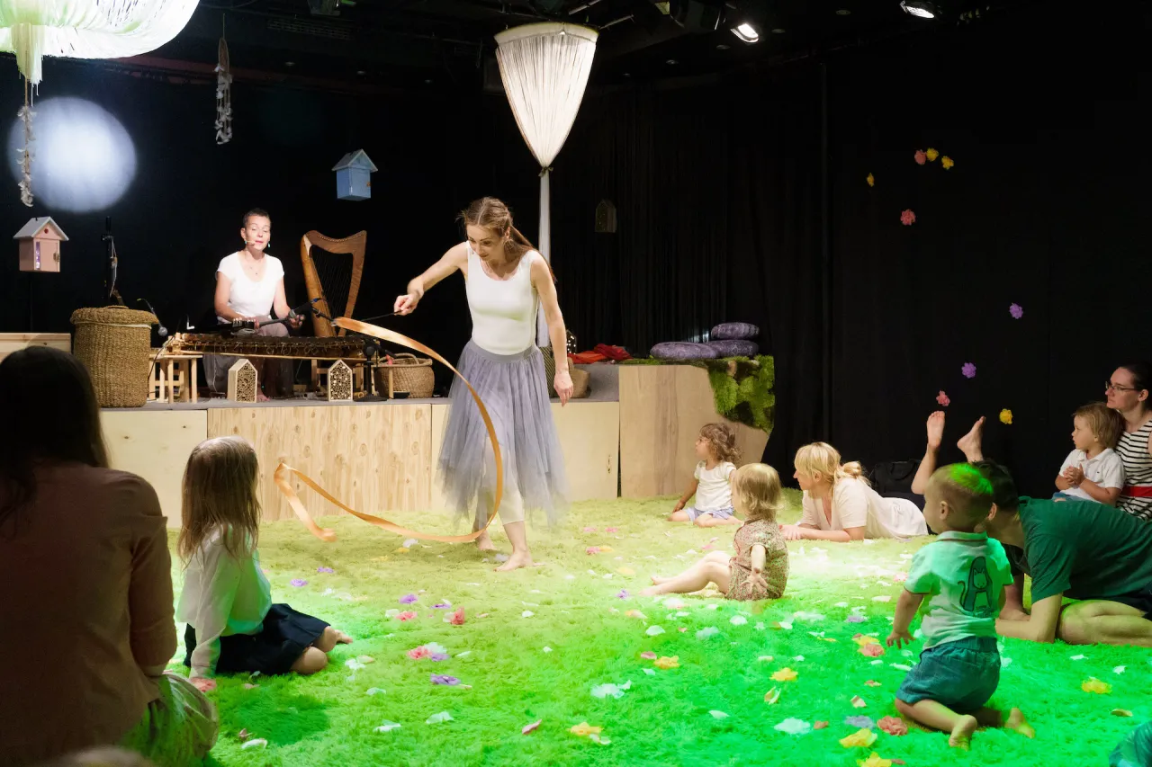 Interaktywny spektakl dla dzieci w Warszawie. Tancerka z wstążką, muzyka na żywo i maluchy na zielonej scenie.