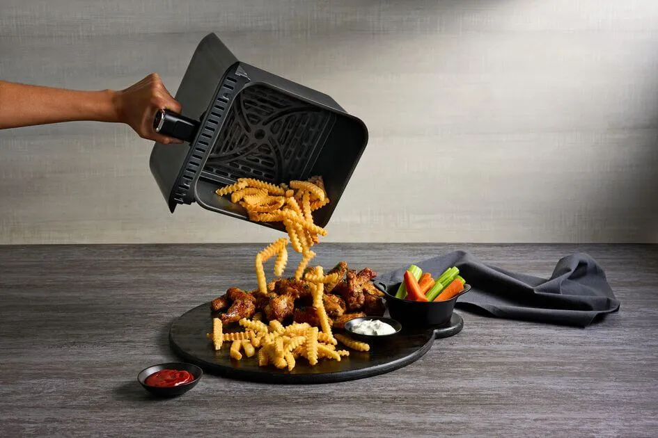 potrząsanie koszykiem frytkownicy beztłuszczowej z frytkami
