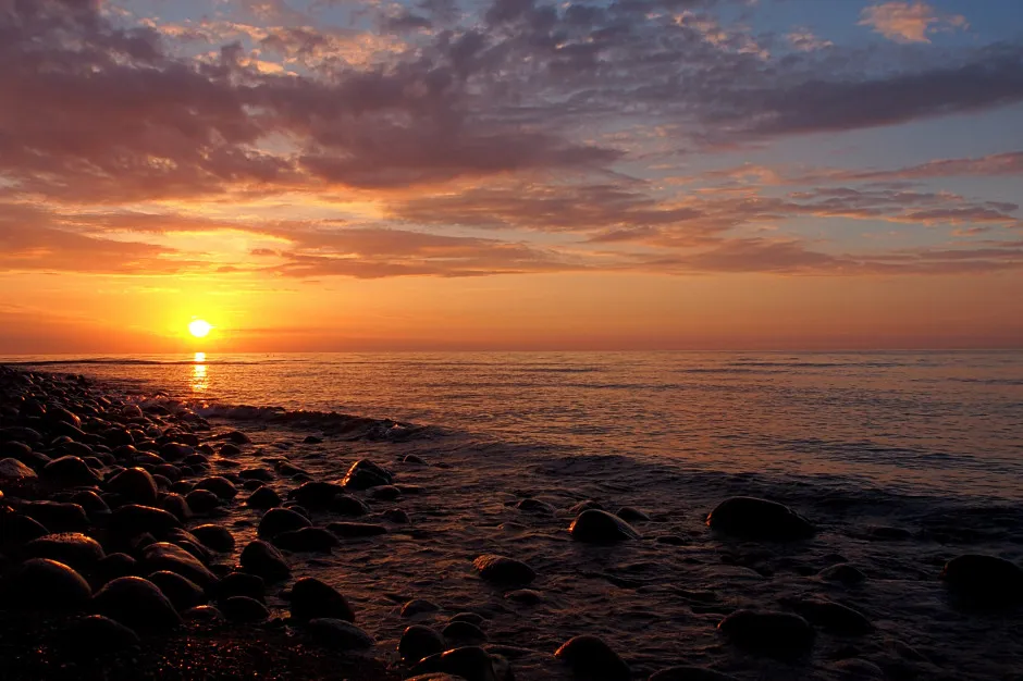 Spokojna plaża nad polskim morzem o zachodzie słońca