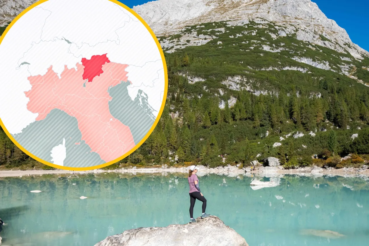 Widok na turkusowe jezioro i g&oacute;ry w Tyrolu we Włoszech. W okręgu mapa Włoch z zaznaczonym regionem.