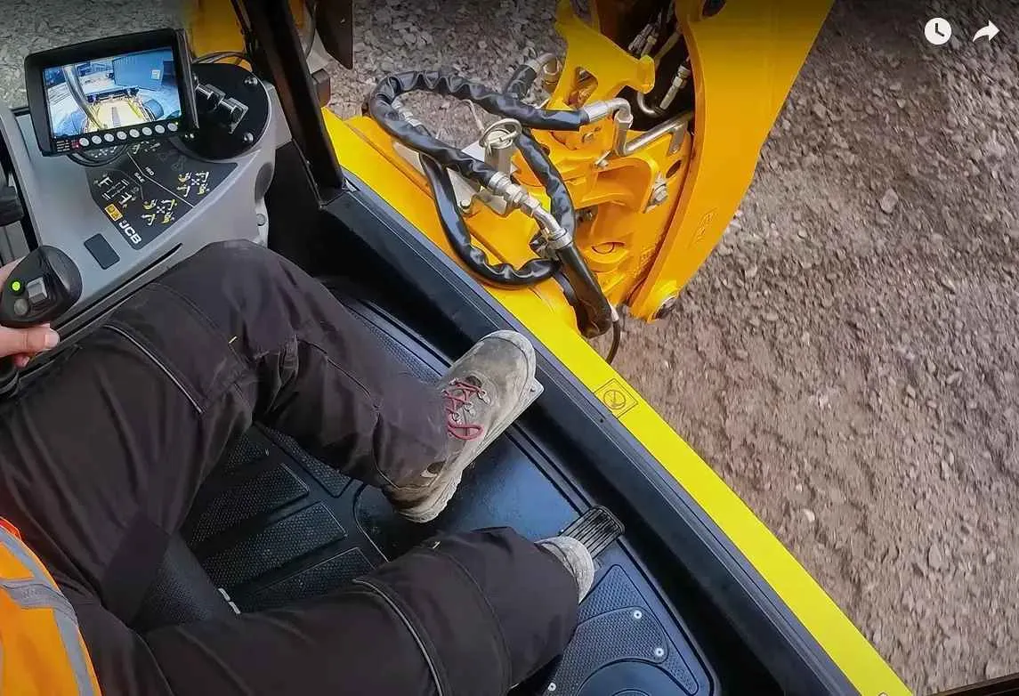 operator koparki w kabinie joysticki