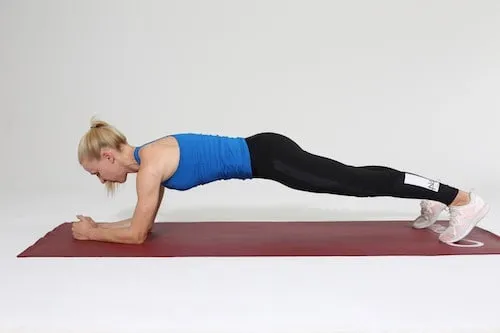 Frau macht Plank Übung zu Hause