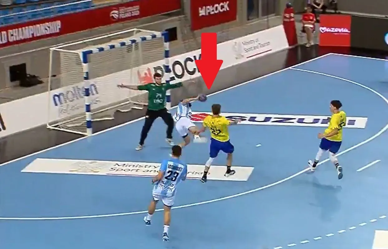 Piłkarz ręczny w białej koszulce rzuca piłkę. Czerwona strzałka wskazuje akcję, kt&oacute;ra może oznaczać niebieską kartkę w piłce ręcznej.