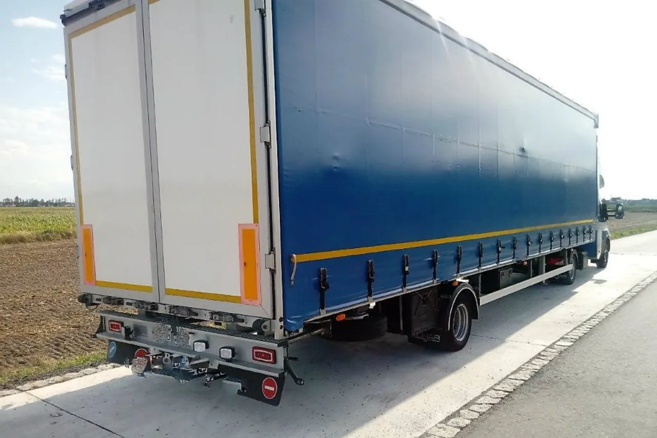 Tylna część niebieskiej naczepy z białymi drzwiami, gotowa do transportu. Jaki bus do 3.5 t na haku? Ten zestaw jest idealny!