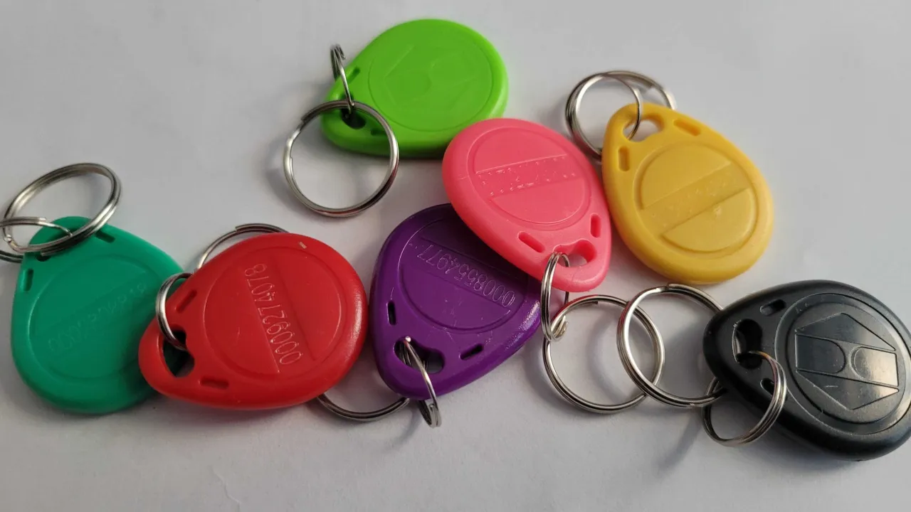 Kolorowe breloczki z numerami, jak ten zielony, czerwony czy żółty, mogą być kluczami do domofonu. Czy można dorobić chip do domofonu? Takie breloczki często zawierają chipy, które można skopiować.
