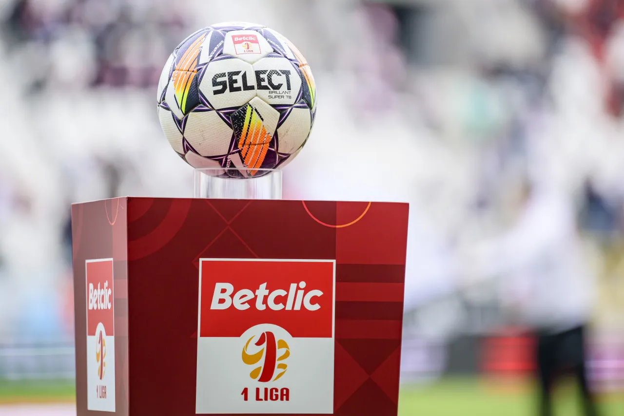Piłka na podium z logo 1 Ligi i Betclic, symbol nadziei na baraże o ekstraklasę.