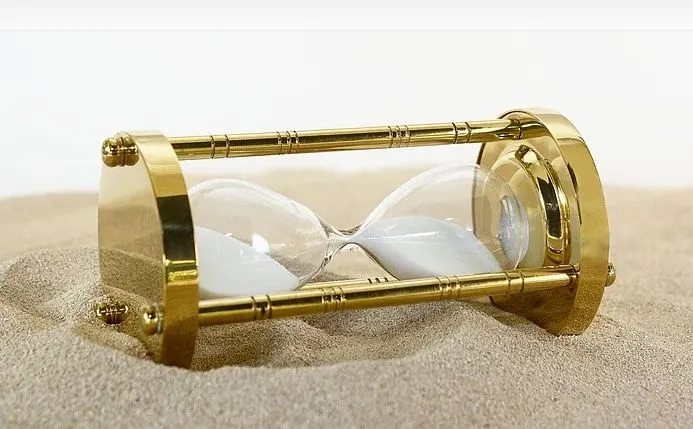 klepsydra i dokumenty symbolizujące upływ czasu w sprawach prawnych