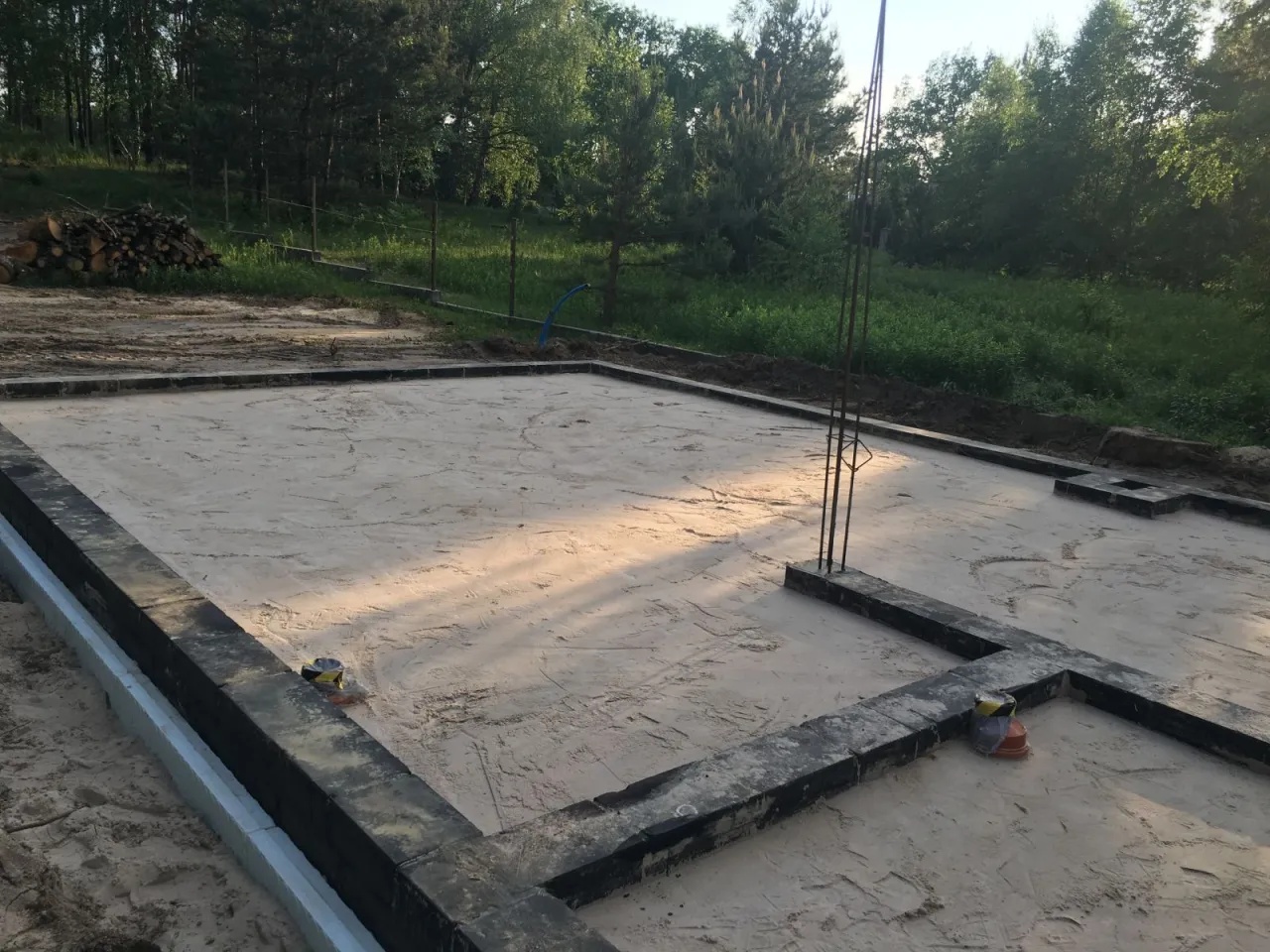 Fundamenty domu na piaskowym podłożu, otoczone betonowymi bloczkami. Czy można zostawić odkryte fundamenty na zimę?