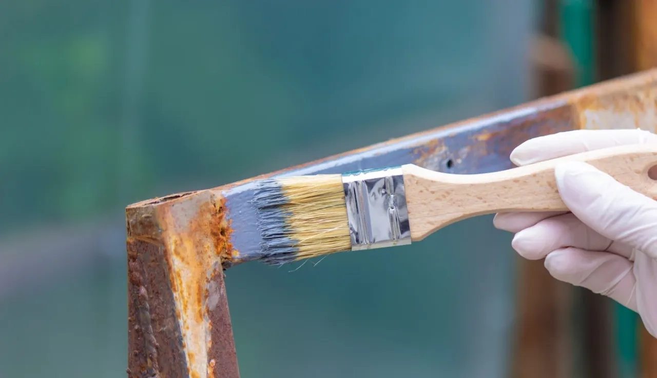 usuwanie rdzy z metalowej ramy huśtawki