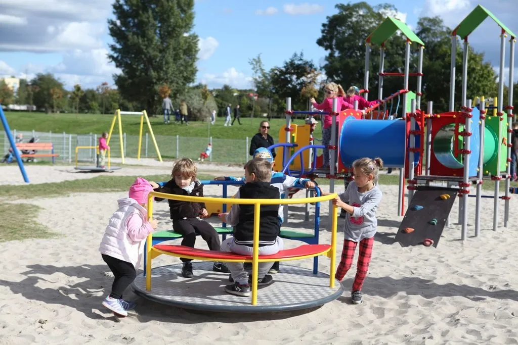 dzieci bawiące się na placu zabaw w różnych warunkach pogodowych