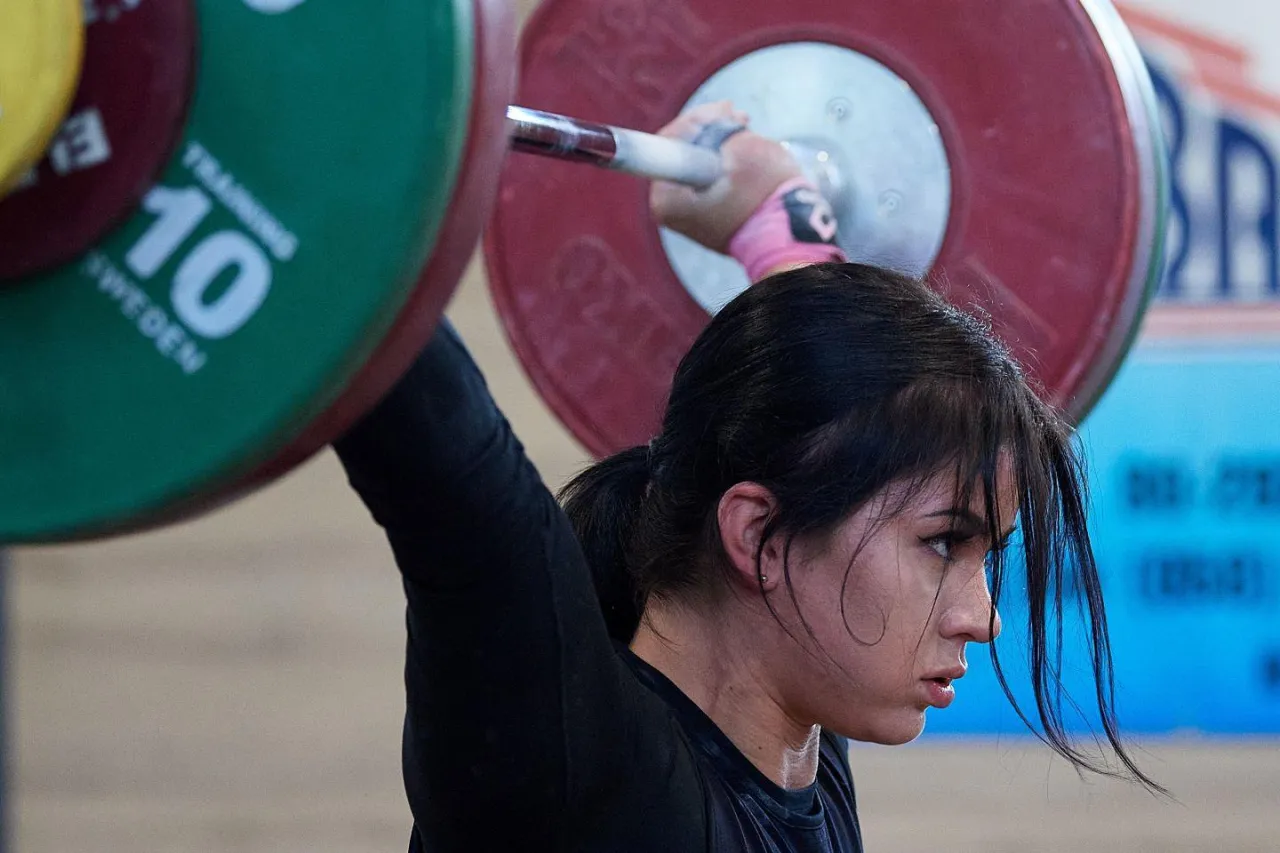 kobieta podnosi ciężary uśmiechnięta