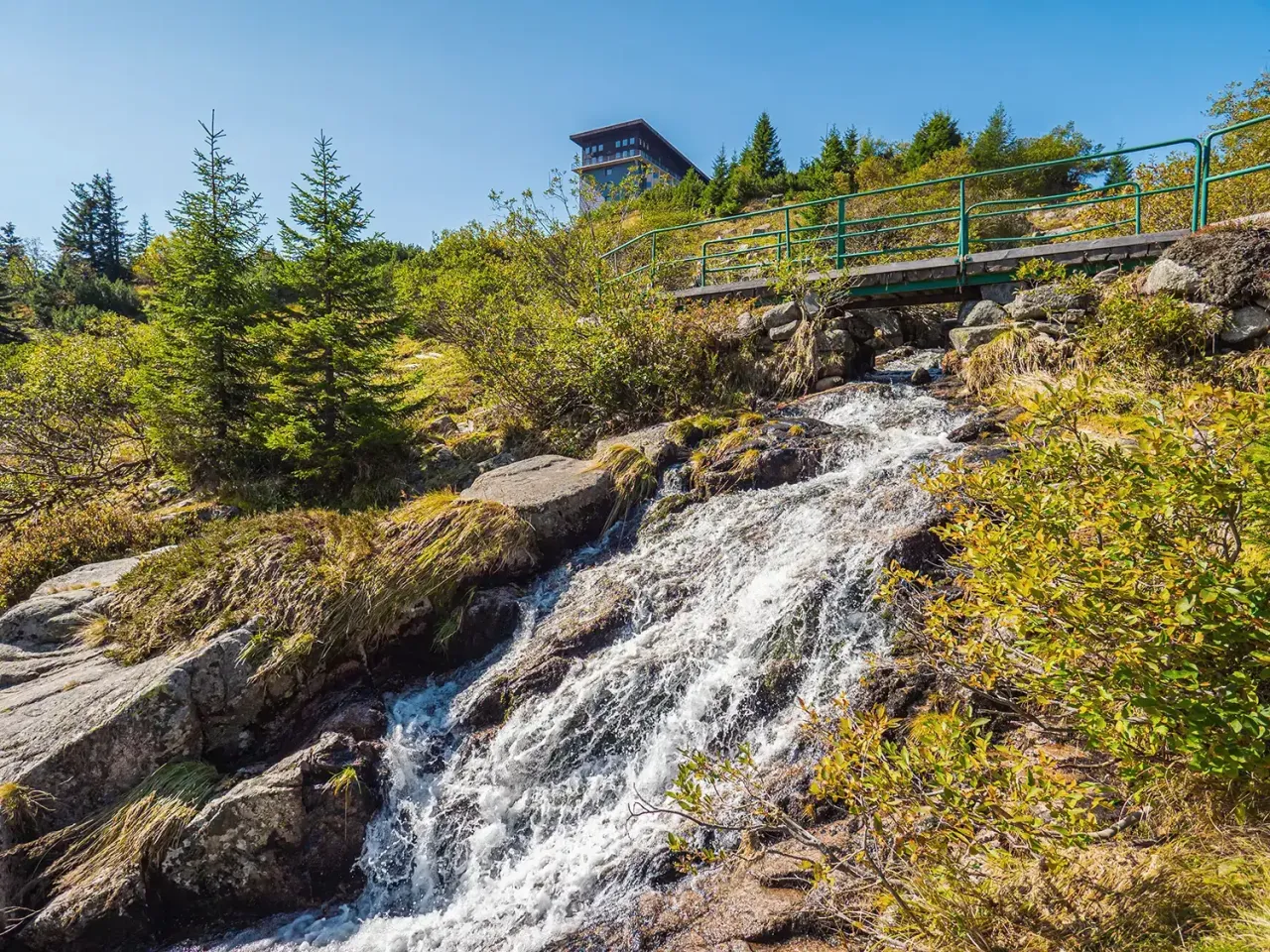 Szklarska Poręba: malowniczy wodospad i mostek na szlaku. Idealne miejsce na wędr&oacute;wkę, by odkryć urok Karkonoszy.