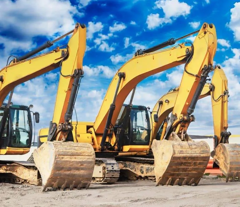 koparka kołowa na drodze i koparka gąsienicowa na placu budowy