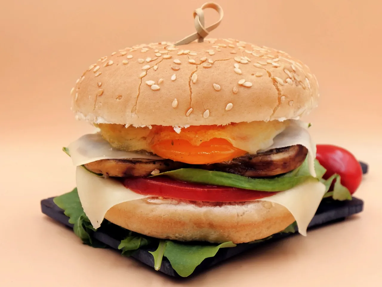 Pyszny wege burger z serem, pomidorem, pieczarkami i jajkiem sadzonym. Zastanawiasz się, ile kalorii ma wege burger?