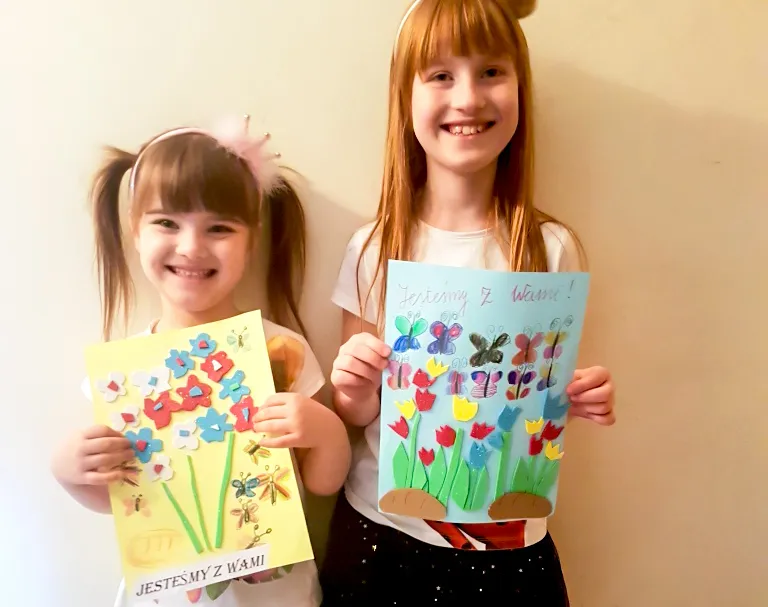 dziecko piszące kartkę pocztową dla dziadków