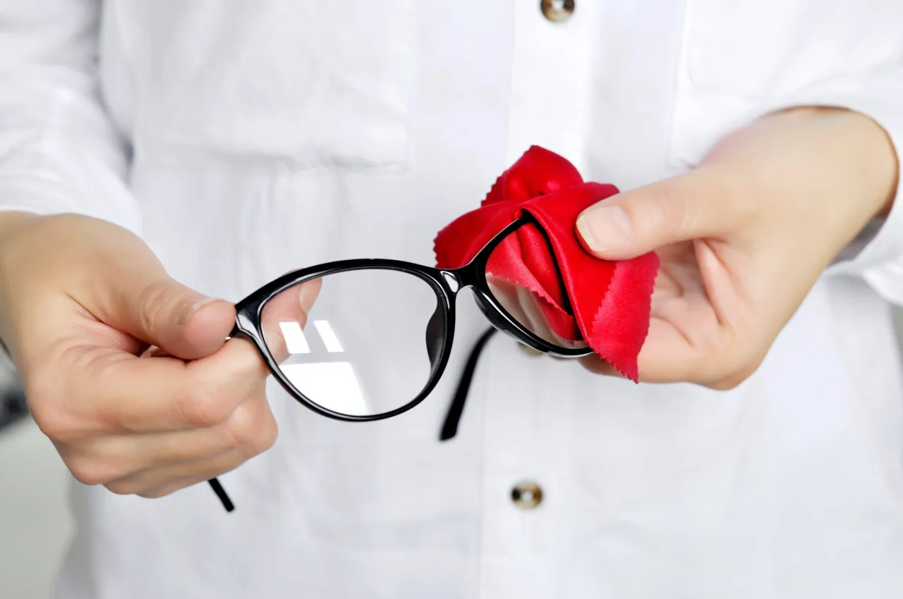 osoba myjąca okulary pod bieżącą wodą