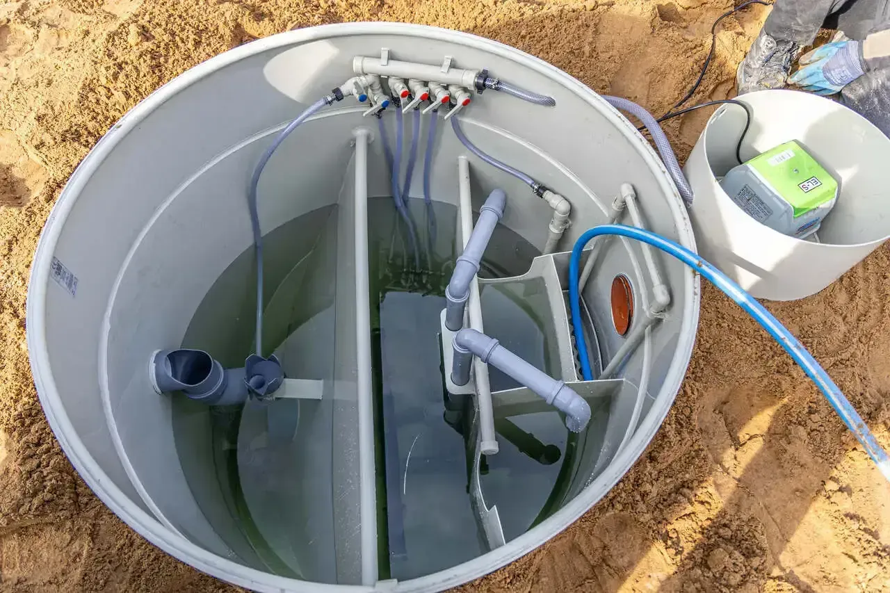 Instalacja systemu napowietrzania oczyszczalni ścieków: widok wnętrza zbiornika z rurami i pompą.