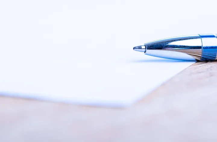 kartka papieru z napisem usprawiedliwienie i długopisem