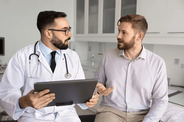 Lekarz konsultuje wyniki badań krwi z pacjentem