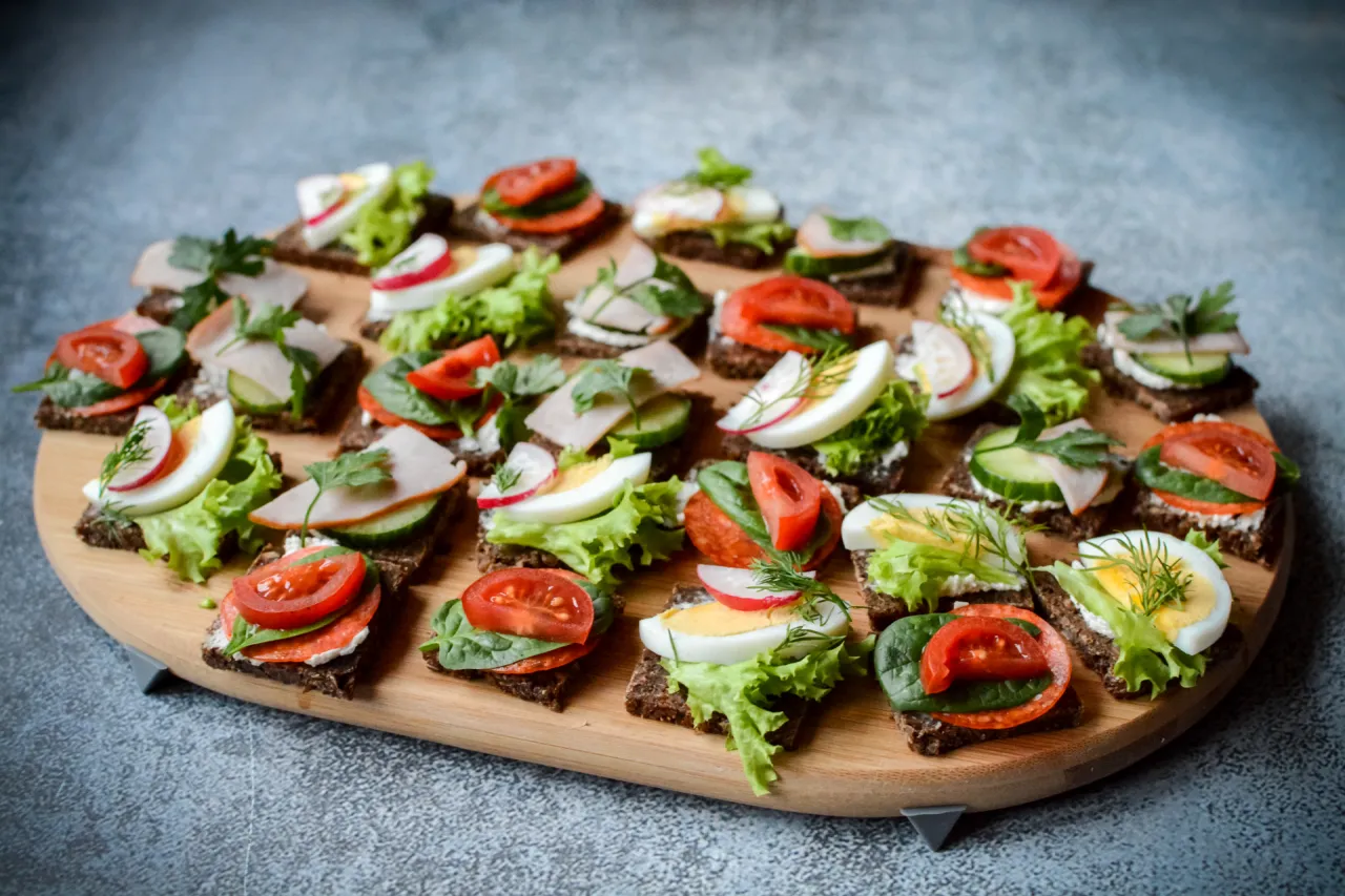 Koreczki z wędliną, jajkiem, pomidorem i rzodkiewką na ciemnym pieczywie. Idealne, by zainspirować, co ugotować na Sylwestra.