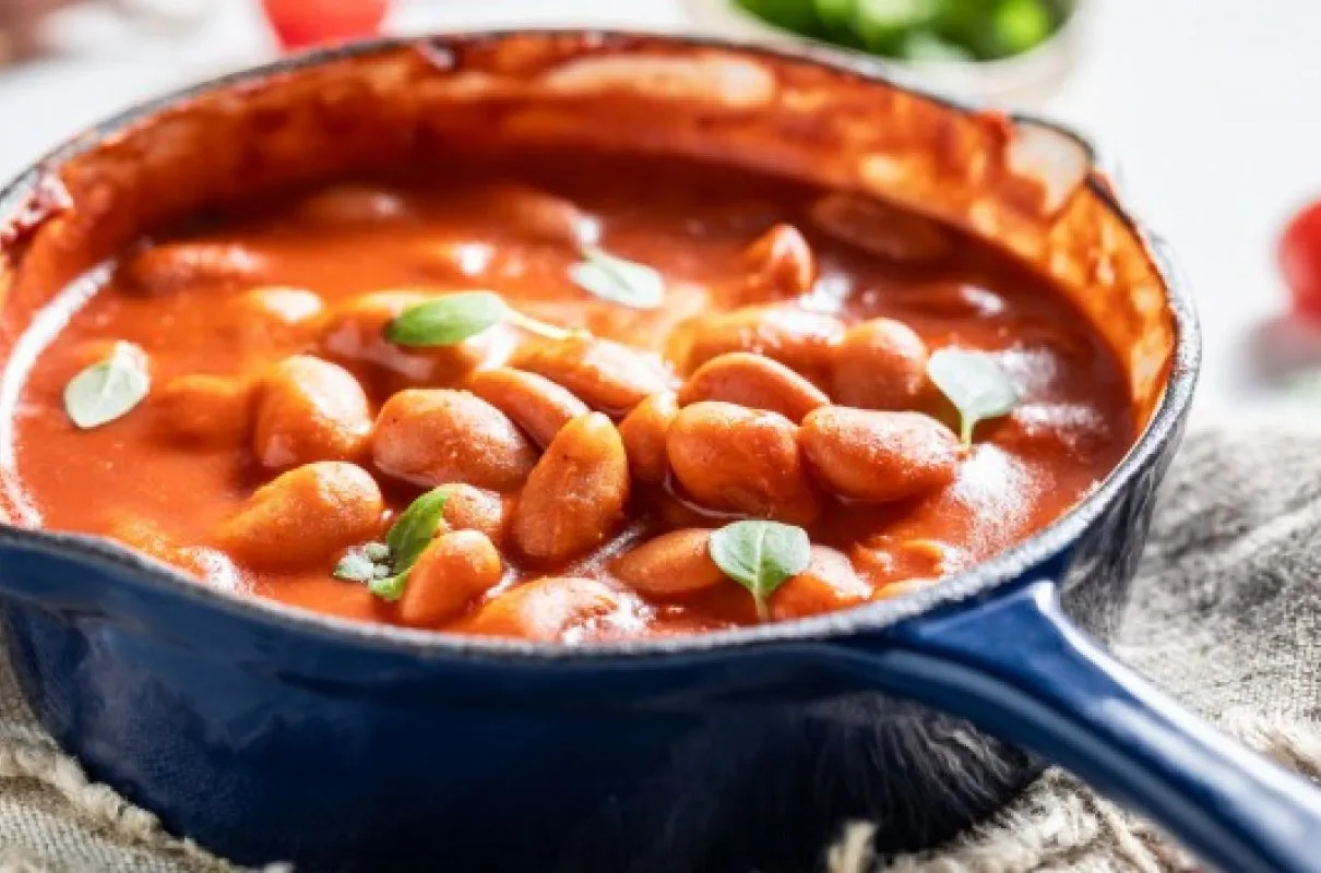 Gęsta, aromatyczna fasolka po bretońsku w sosie pomidorowym, ozdobiona listkami bazylii. Idealna na chłodne dni, czy to fasolka po bretońsku, czy chilli con carne.