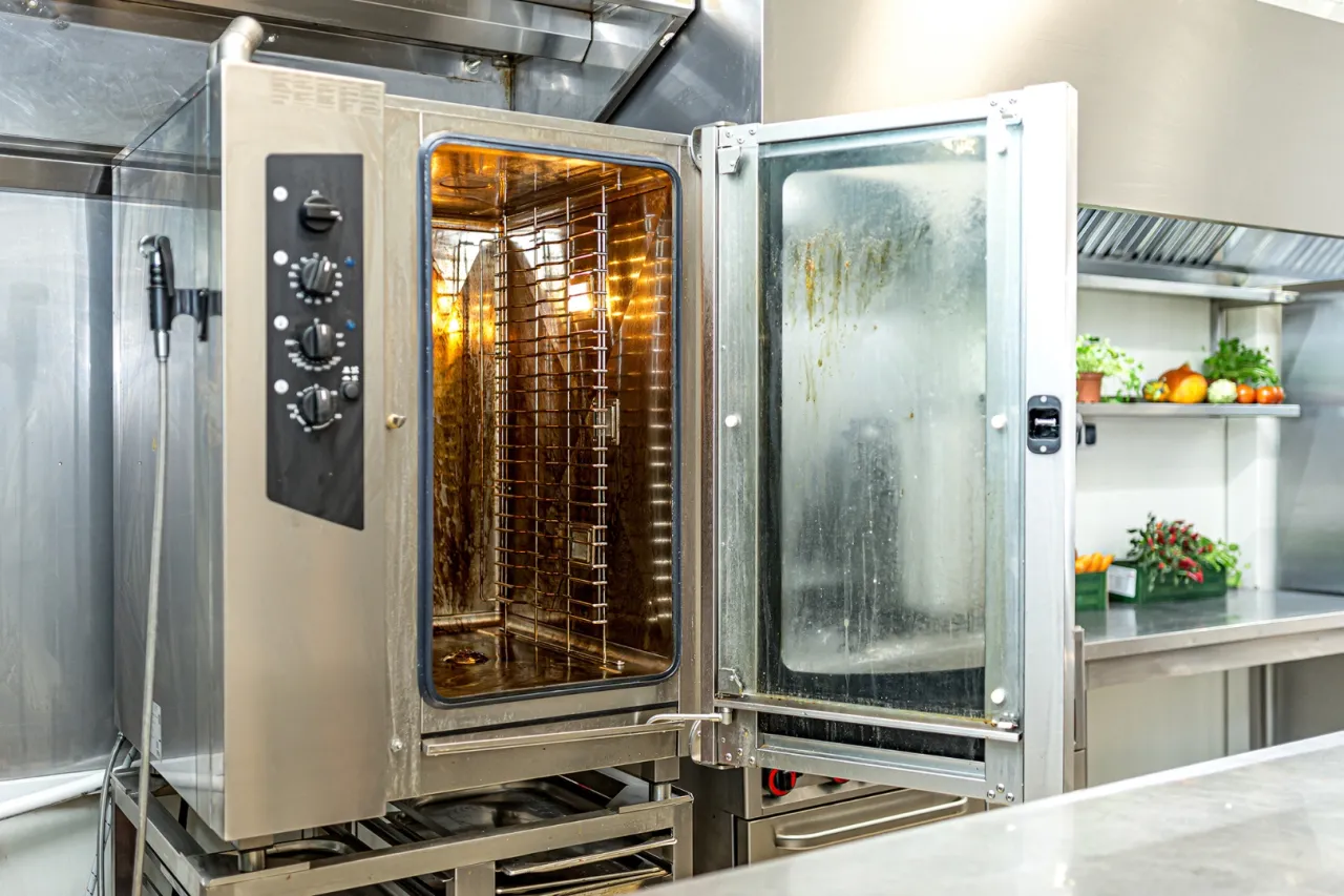 Otwarty piec konwekcyjny z widocznymi zabrudzeniami, które mogą być ukryte siedliska bakterii w kuchni o których zapominasz przy porządkach.