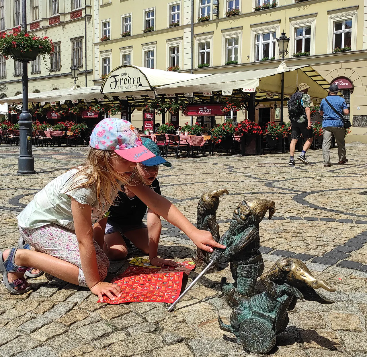 dzieci szukające figurek krasnali na rynku we Wrocławiu