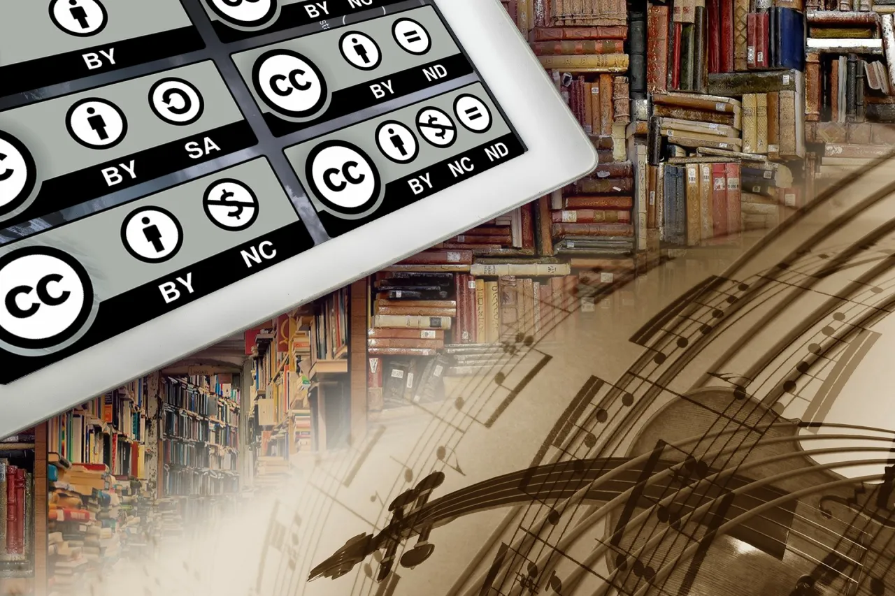 Ikony licencji Creative Commons na tablecie, symbolizujące wolne oprogramowanie, na tle biblioteki i nut.