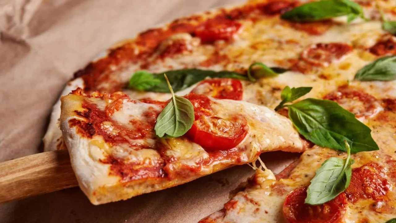 masa de pizza casera en un bol de cristal junto a una Thermomix