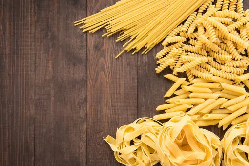 r&oacute;żne kształty makaronu na drewnianej desce
