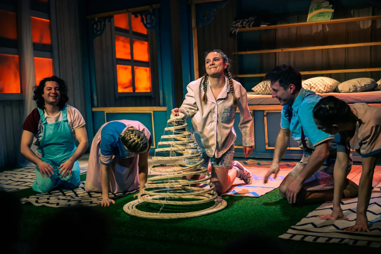 Wesołe przedstawienie teatralne dla dzieci. Aktorzy bawią się na scenie, tworząc magiczną atmosferę.