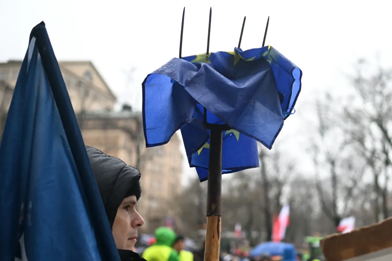 Rolnicy protestują przeciwko zielonemu ładowi. Flaga UE na widłach, symbol sprzeciwu.