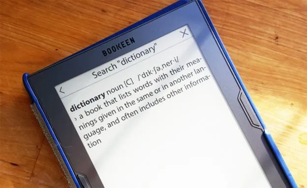 stary słownik książkowy obok nowoczesnego laptopa lub smartfona