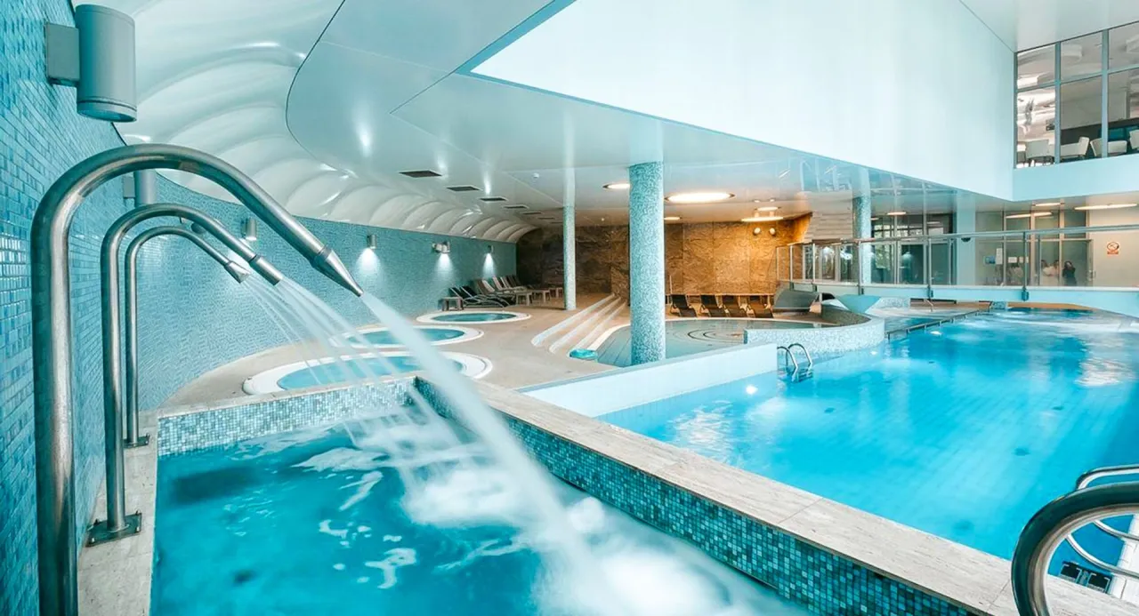 Basen i jacuzzi w hotelu dla dorosłych. Relaks w wodzie z hydromasażem i prysznicami wodnymi.