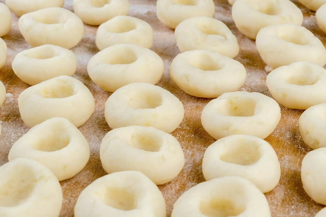 Ręce formujące kluski śląskie z dziurką