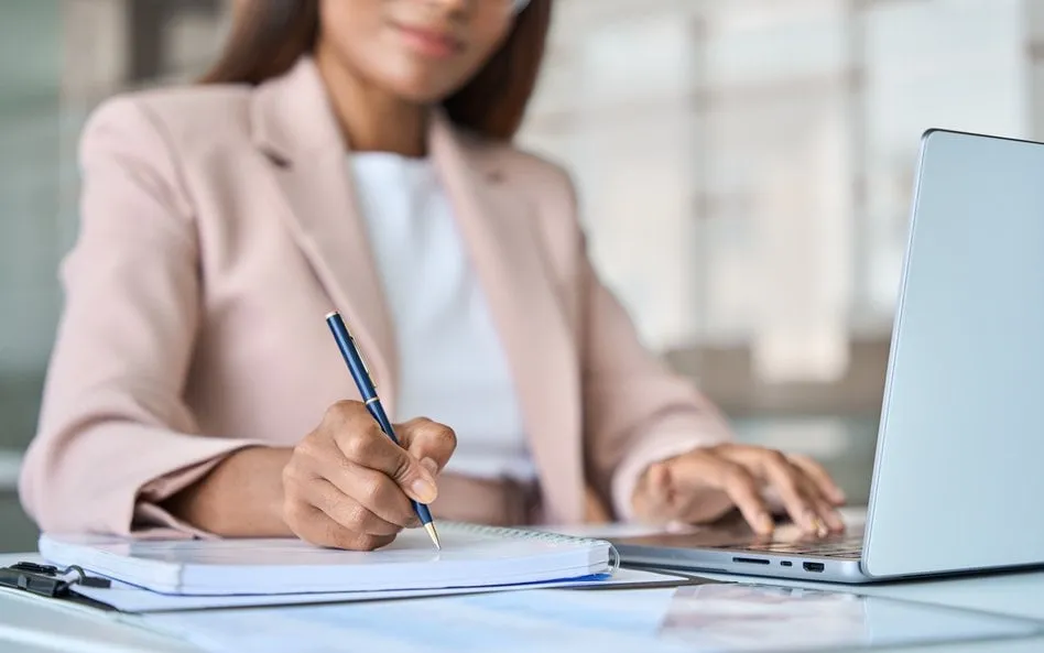 kobieta pisząca w notatniku cele na nowy rok