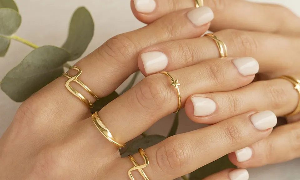 kobieta nosząca wiele pierścionk&oacute;w na jednym palcu, stacking rings