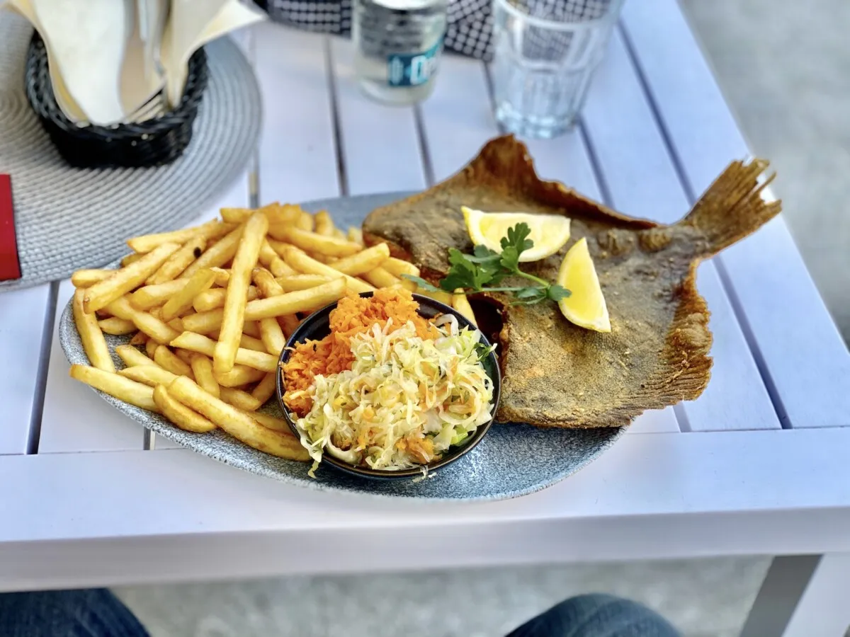 Świeża smażona ryba z frytkami i sur&oacute;wką nad morzem