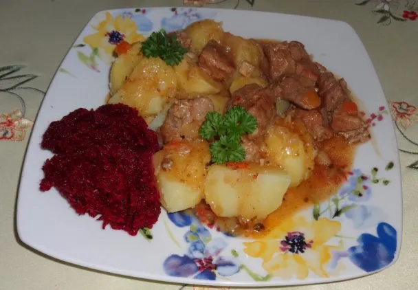 gulasz wieprzowy na talerzu z ziemniakami