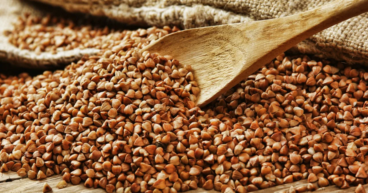 Drewniana łyżka na stercie ziaren gryki. Czy kasza gryczana jest zdrowa? Tak, to bogactwo błonnika i minerał&oacute;w!