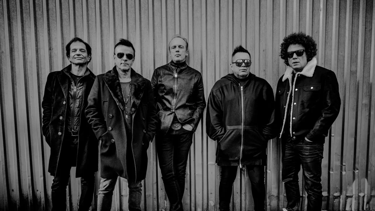 Pięciu mężczyzn w czarnych ubraniach pozuje przed falistą ścianą. Naprawdę jaka jesteś nie wie nikt, kto śpiewa.