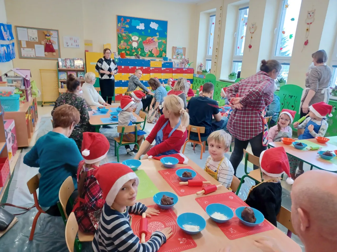 Dzieci w mikołajkowych czapkach tworzą świąteczne wypieki. Wesołe pomysły na warsztaty świąteczne w przedszkolu.