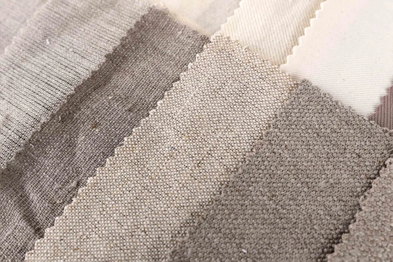 Pr&oacute;bki tkanin w odcieniach beżu i brązu, ukazujące r&oacute;żne rodzaje splot&oacute;w. Widać tu między innymi gruby, lniany typ jedwabiu.