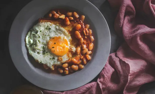 Fasolka w sosie pomidorowym z jajkiem sadzonym i ziołami